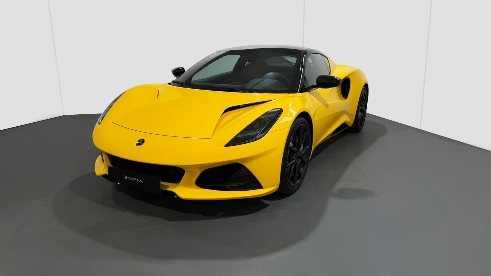 Lotus Emira V6 gialla ripresa di tre quarti su sfondo bianco.
