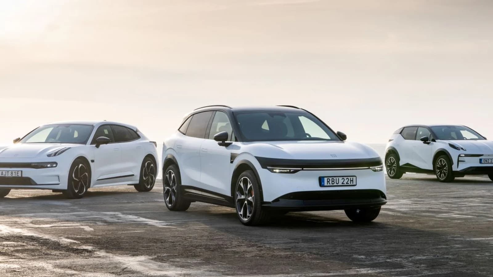 Tre auto elettriche Zeekr chiare parcheggiate in fila in uno scenario aperto.