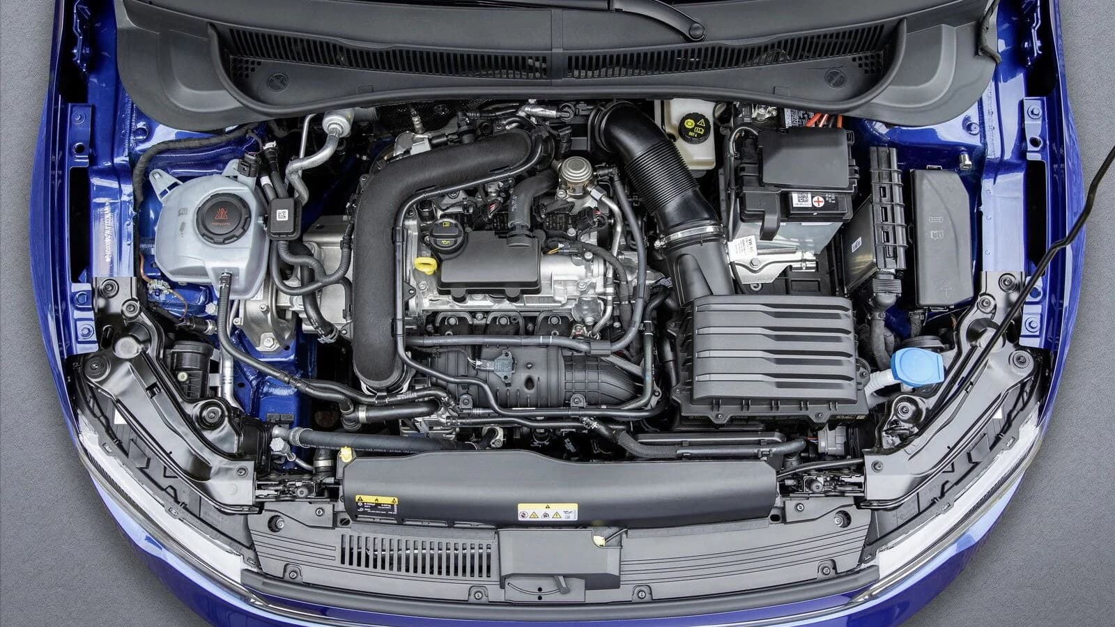 Fotografia ravvicinata del vano motore di un'automobile nella copertina sul tre cilindri Volkswagen.