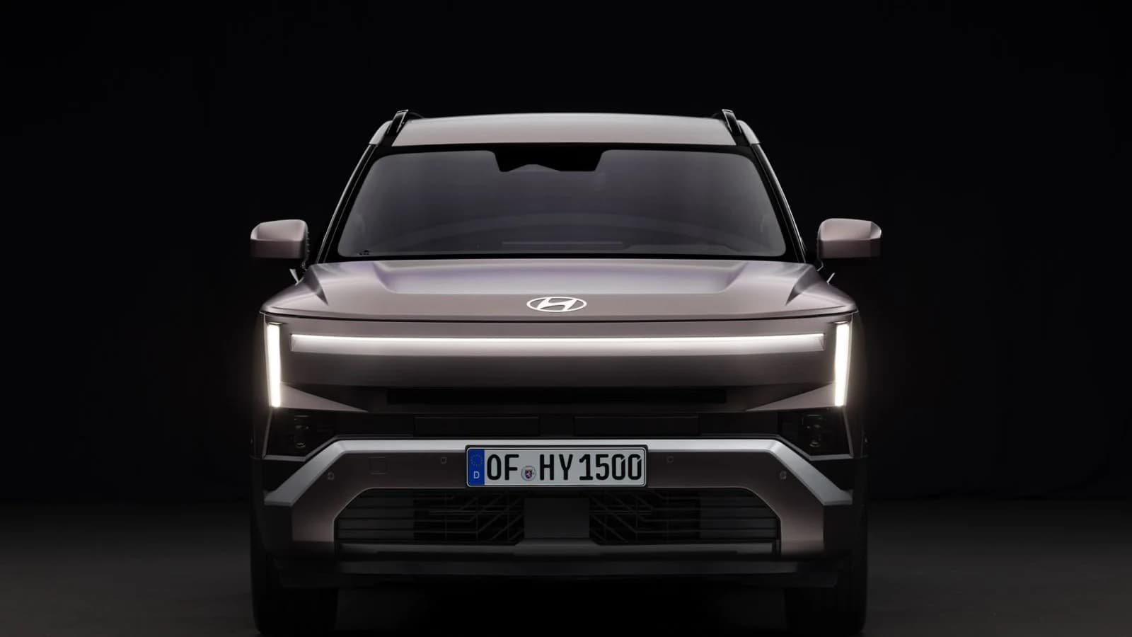 Vista frontale di una Hyundai Tucson grigia su sfondo scuro.