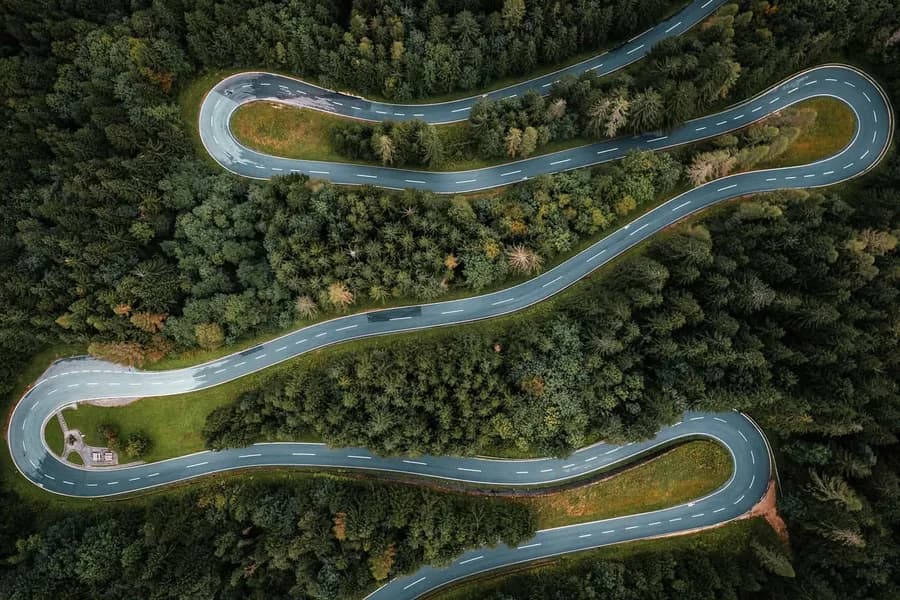Vista aerea di una tortuosa strada di montagna circondata da foreste.