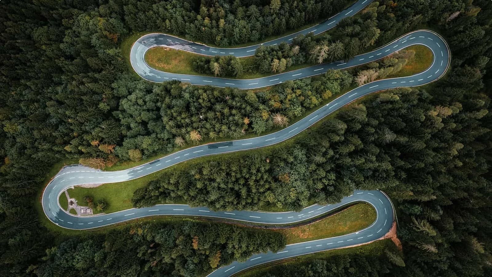 Vista aerea di una tortuosa strada di montagna circondata da foreste.