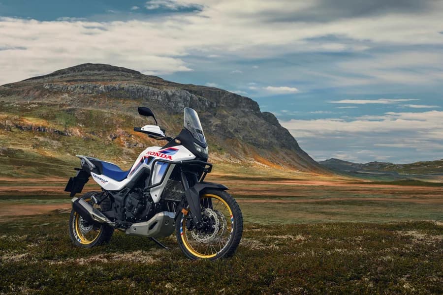 Honda XL750 Transalp in un paesaggio di montagna, con un motociclista in sella.