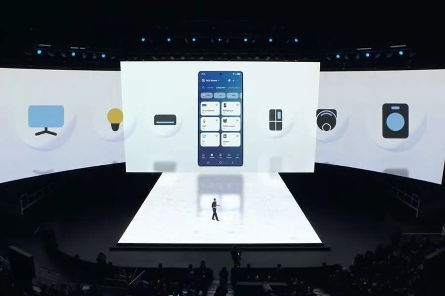 Presentazione Samsung con schermi e dispositivi Galaxy S26 illuminati sul palco.