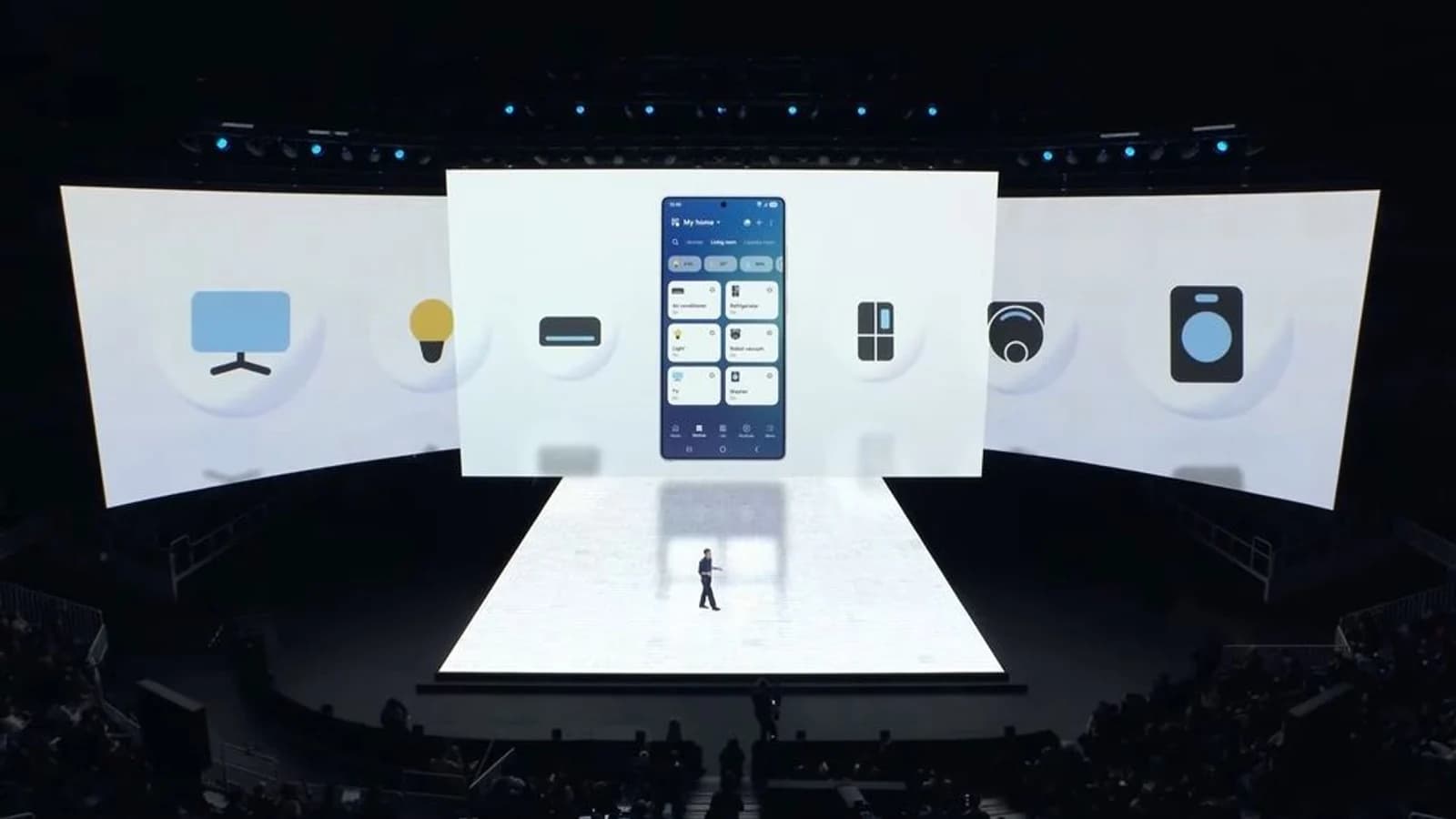 Presentazione Samsung con schermi e dispositivi Galaxy S26 illuminati sul palco.