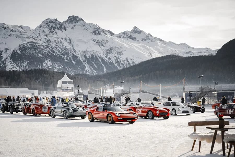 Raduno di auto sportive d'epoca sulla neve davanti alle montagne di St. Moritz.