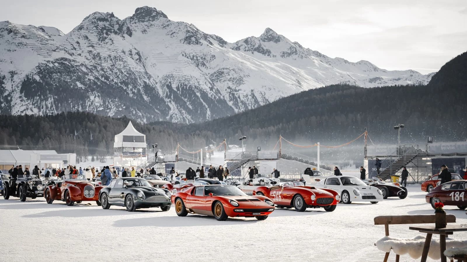 Raduno di auto sportive d'epoca sulla neve davanti alle montagne di St. Moritz.