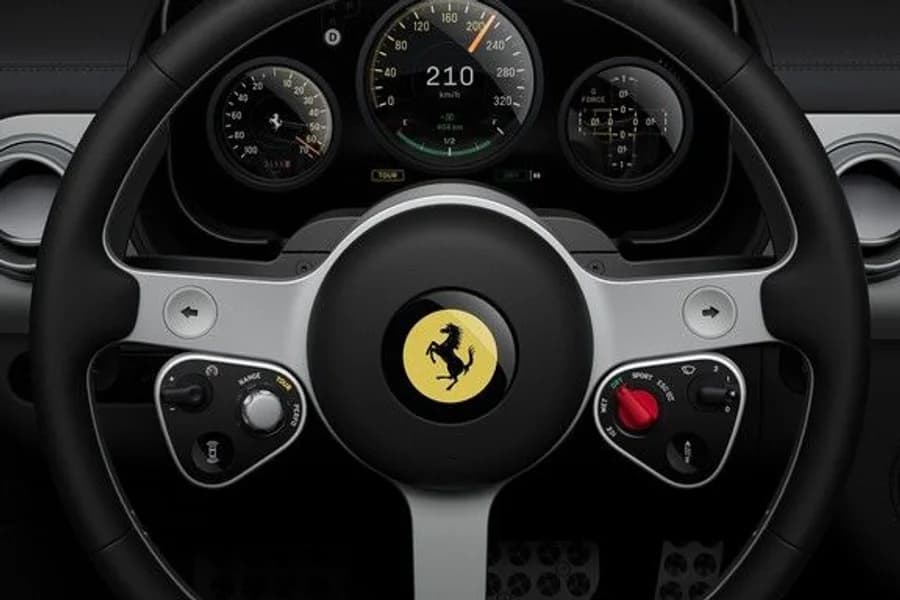 Volante di una Ferrari con stemma del Cavallino e comandi multifunzione.